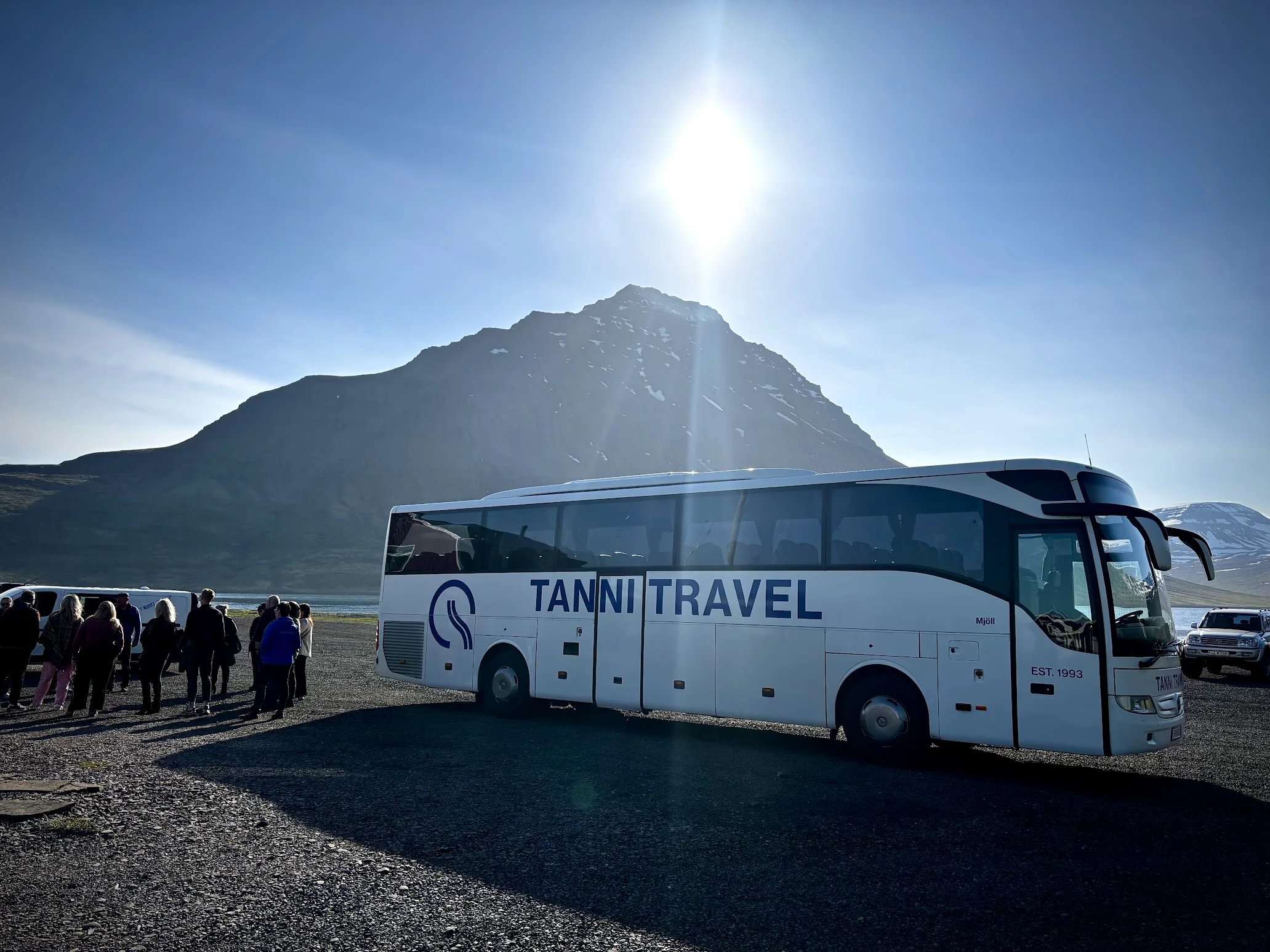 Tanni Travel coach with passengers beside Icelandic mountains