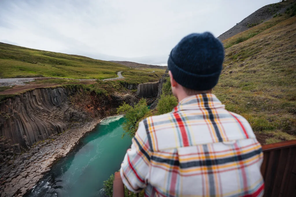 A visitor looking across Stuðlagil Canyon from the west-side viewpoint
