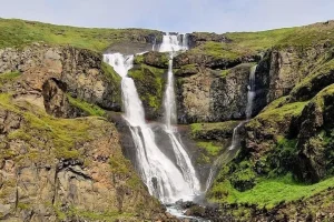 Rjúkandi Waterfall cascading down a green hillside