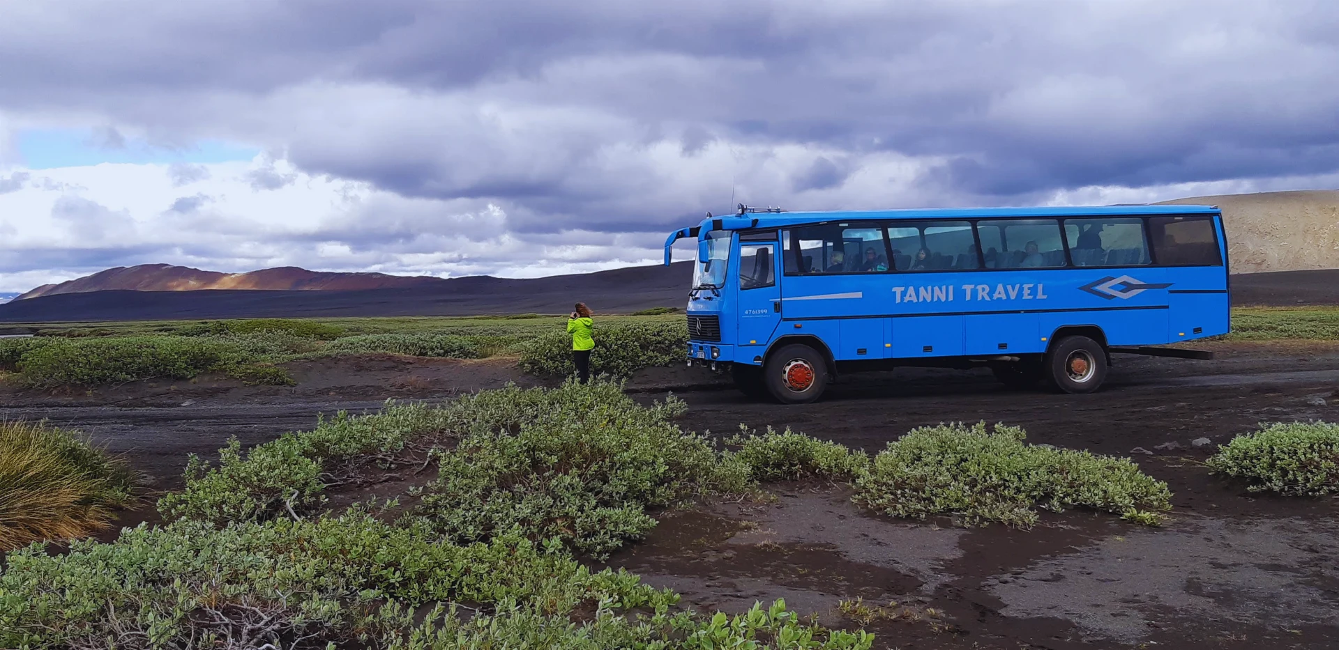 A blue Tanni Travel bus in the Icelandic highlands